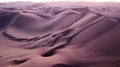 Aerial top-down view of sand dunes during the sunset creating abstract shapes due to wind formations.