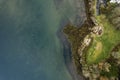 Aerial top down view on a small picnic area by the ocean. Wooden tables and seat. Blue color water. Roundstone, county Galway,