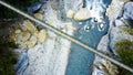 Aerial top-down view of suspension bridge above the blue water mountainous river