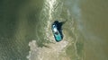 Aerial top down view of tug boat manoeuvring in shallow green sea water. Royalty Free Stock Photo