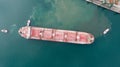 Aerial top down view of Tug boats assisting big cargo ship. Large cargo ship enters the port escorted by tugboats Royalty Free Stock Photo