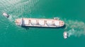 Aerial top down view of Tug boats assisting big cargo ship. Large cargo ship enters the port escorted by tugboats Royalty Free Stock Photo