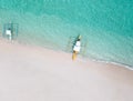 Aerial top down view of white sand beach with a traditional philippine boats beached on it