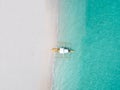 Aerial top down view of white sand beach with a traditional philippine boats beached on it Royalty Free Stock Photo