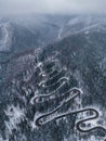 Aerial top down view of winter winding road in the forest, Transylvania, Romania. Royalty Free Stock Photo