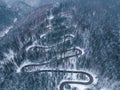 Aerial top down view of winter winding road in the forest, Transylvania, Romania. Royalty Free Stock Photo