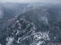 Aerial top down view of winter winding road in the forest, Transylvania, Romania. Royalty Free Stock Photo