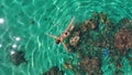 Aerial top down woman snorkel in crystal sea water