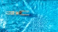 Aerial top view of active woman in swimming pool from above, girl swims in blue water, tropical vacation, holiday on resort