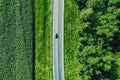 Aerial top view of a asphalt road with a car through .green forest and corn field Royalty Free Stock Photo