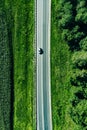 Aerial top view of a asphalt road with a car through .green forest and corn field Royalty Free Stock Photo