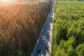 Aerial top view of asphalt road between green summer forest at sunny summer day Royalty Free Stock Photo