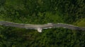 Aerial top view of asphalt roads in the forest and small tourist car parked on side of the road Royalty Free Stock Photo