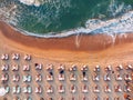 Aerial top view on the beach shore and sea. Umbrellas, sand and sea waves Royalty Free Stock Photo