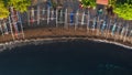 Aerial top view of beautiful bay on ocean shore with white Jukung fishing boats and tropical green. Sea waves rolling on Royalty Free Stock Photo