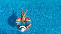 Aerial top view of beautiful girl in swimming pool from above, relax swim on inflatable ring donut and has fun in water Royalty Free Stock Photo