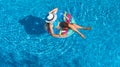 Aerial top view of beautiful girl in swimming pool from above, relax swim on inflatable ring donut and has fun in water Royalty Free Stock Photo