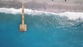 Aerial top view of a blue sea and wooden pier. Clip. Sandy beach with people sunbathing outdoors, concept of summer Royalty Free Stock Photo