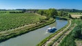 Aerial top view of boat in Canal du Midi from above, family travel by barge and vacation in France Royalty Free Stock Photo