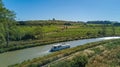 Aerial top view of boat in Canal du Midi from above, family travel by barge and vacation in France Royalty Free Stock Photo