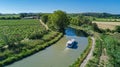 Aerial top view of boat in Canal du Midi from above, family travel by barge and vacation in France Royalty Free Stock Photo