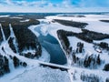 Aerial top view of bridge road above frozen river in snow winter Finland