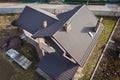 Aerial top view of building steep shingle roof, brick chimneys and small attic window on house top with metal tile roof. Roofing,