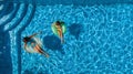 Aerial top view of children in swimming pool from above, happy kids swim on inflatable ring donuts and have fun in water Royalty Free Stock Photo