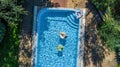 Aerial top view of children in swimming pool from above, happy kids swim on inflatable ring donuts and have fun in water Royalty Free Stock Photo