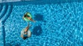 Aerial top view of children in swimming pool from above, happy kids swim on inflatable ring donuts and have fun in water Royalty Free Stock Photo