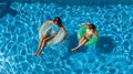 Aerial top view of children in swimming pool from above, happy kids swim on inflatable ring donuts and have fun in water Royalty Free Stock Photo