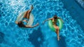 Aerial top view of children in swimming pool from above, happy kids swim on inflatable ring donuts and have fun in water Royalty Free Stock Photo