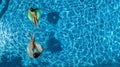 Aerial top view of children in swimming pool from above, happy kids swim on inflatable ring donuts and have fun in water Royalty Free Stock Photo