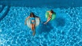 Aerial top view of children in swimming pool from above, happy kids swim on inflatable ring donuts in water on family Royalty Free Stock Photo