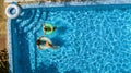 Aerial top view of children in swimming pool from above, happy kids swim on inflatable ring donuts in water on family Royalty Free Stock Photo