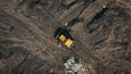 Aerial top view of a construction site or country dump with yellow excavator or bulldozer, heavy equipment, drone photo