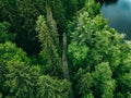 Aerial top view of country road in green summer forest and blue lake. Rural landscape in Finland Royalty Free Stock Photo