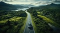 Aerial top view of country road through green woods and blue lakes