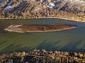 Aerial top view, countryside panorama of small island with dry grass in quiet river on sunny day. Drone photography Royalty Free Stock Photo