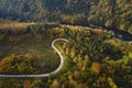 Aerial top view of curvy road through autumn forest in mountains Royalty Free Stock Photo