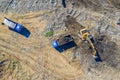 Aerial top view of excavator and dump trucks Royalty Free Stock Photo