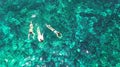 Aerial top view of family snorkeling from above, mother and kids snorkelers swimming in a clear tropical sea water with corals Royalty Free Stock Photo