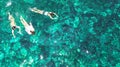 Aerial top view of family snorkeling from above, mother and kids snorkelers swimming in a clear tropical sea water with corals Royalty Free Stock Photo