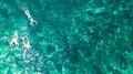 Aerial top view of family snorkeling from above, mother and kids snorkelers swimming in a clear tropical sea water with corals Royalty Free Stock Photo