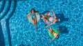 Aerial top view of family in swimming pool from above, happy mother and kids swim on inflatable ring donuts and have fun in water Royalty Free Stock Photo