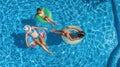 Aerial top view of family in swimming pool from above, happy mother and kids swim on inflatable ring donuts and have fun in water