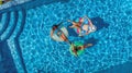 Aerial top view of family in swimming pool from above, happy mother and kids swim on inflatable ring donuts and have fun in water Royalty Free Stock Photo