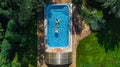 Aerial top view of family in swimming pool from above, happy mother and kids swim on inflatable ring donuts and have fun in water Royalty Free Stock Photo