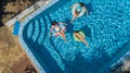 Aerial top view of family in swimming pool from above, mother and kids swim and have fun in water on family vacation Royalty Free Stock Photo