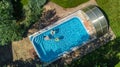 Aerial top view of family in swimming pool from above, mother and kids swim and have fun in water on family vacation Royalty Free Stock Photo